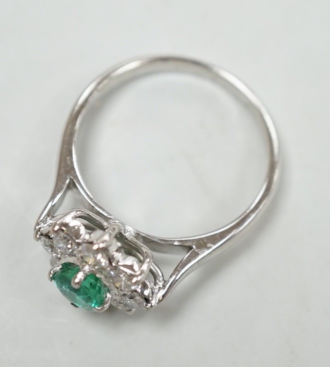 A modern 18k white metal, emerald and diamond set flower head cluster ring, size N, gross weight 4.5 grams.